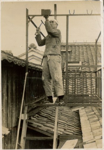 足場の上で板金を打つ初代（1950年代）