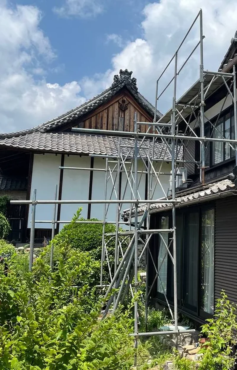 足場を組んで入母屋破風の工事をおこなっている屋根まわりの様子