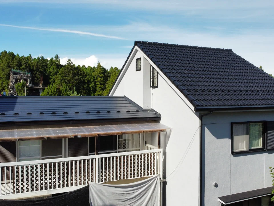 工事を終えた住宅の全景。塗り直した大屋根と葺き替えた金属屋根がそろった外観